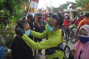 Sambil Gowes di Gresik Selatan, Pak Qosim Bagikan Masker kepada Warga