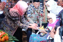 Sambut Kedatangan Jemaah Haji Kloter 87, Gubernur Khofifah Potong Tumpeng dan Bagikan Bendera Merah Putih